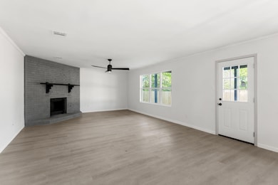 Unfurnished living room featuring baseboards, orn