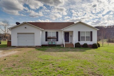 ONE CAR GARAGE ON THE FRONT OF THE HOME WITH GRAVEL DRIVEWAY