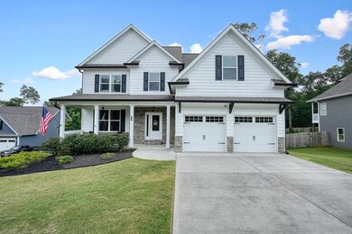 Craftsman-style home featuring a garage, stone siding, concrete driveway, and a shingled roof