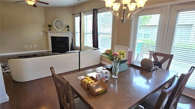 Dining space featuring a chandelier, a fireplace, and ceiling fan