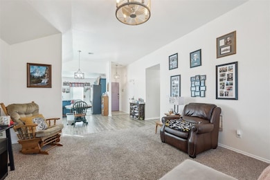 Carpeted living room featuring a chandelier and lo