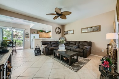 Living area with a ceiling fan and light tile patt