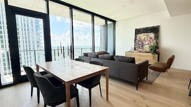Dining area with a wall of windows, light wood fi