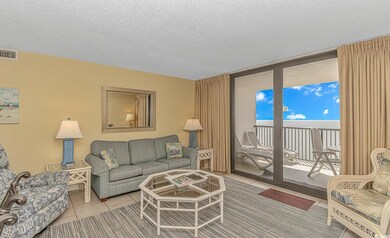 Tiled living room featuring a textured ceiling and floor to ceiling windows