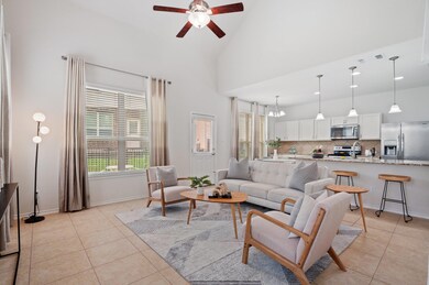 Living area with ceiling fan, light tile patterne