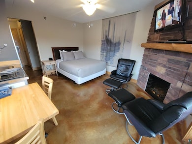 Bedroom with ceiling fan and a fireplace