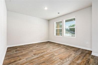 Spare room with wood finished floors and recessed lighting