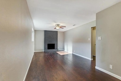 Unfurnished living room featuring ceiling fan, wo