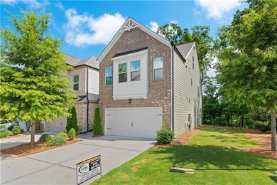 View of front of property featuring brick siding, an attached garage, driveway, and a front yard