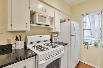 Kitchen with white appliances, crown molding, whi