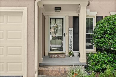 View of exterior entry with an attached garage, stucco siding, and a porch