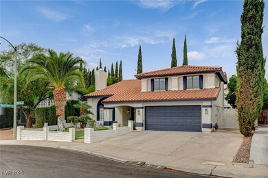 Mediterranean / spanish-style house featuring a gate, concrete driveway, stucco siding, a tiled roof, and a chimney