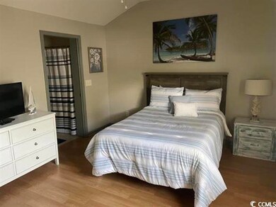 Bedroom with lofted ceiling, dark wood-type flooring, and a ceiling fan