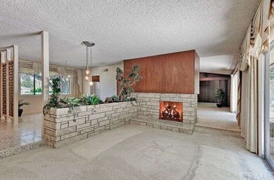Step-down formal living room with stone fireplace.
