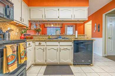 Kitchen with white cabinetry, black appliances, ki