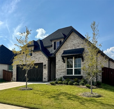 French country style house featuring brick siding, driveway, and a shingled roof