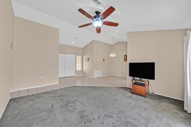 Living room featuring tile flooring, vaulted ceili