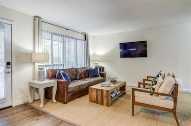 Living room with hardwood / wood-style flooring an