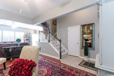 Entrance foyer featuring stairway, light tile patterned floors, and a ceiling fan