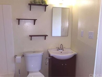 Cute bathroom has newer low flush toilet, sink and