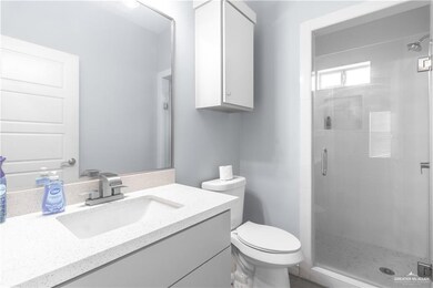 Bathroom featuring vanity, a shower stall, and toilet