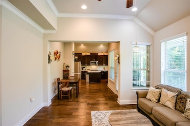 Living room featuring ceiling fan, vaulted ceilin