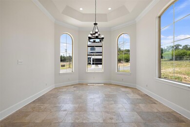 Unfurnished dining area featuring ornamental molding, a chandelier, a raised ceiling, light stone finish flooring, and recessed lighting