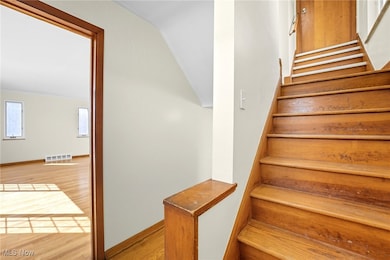 Stairs with wood finished floors and baseboards