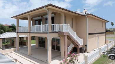 Rear view of property with stucco siding, stairwa