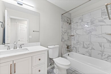 Bathroom featuring bathing tub / shower combination, vanity, and a textured ceiling