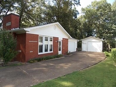 Side of home. Concrete Driveway. 2 Car Attached garage and separate 1 Car Garage/Workshop.  