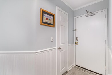 Entryway with crown molding and wainscoting