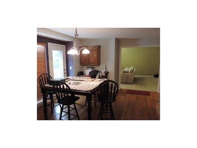 Eating area of kitchen with hardwood floors. Entry