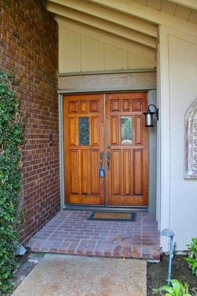 Double door entry with brick accents.