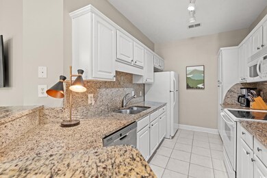 Kitchen with white cabinetry, light tile patterned