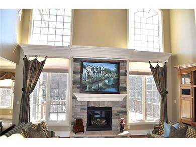 Great Room. Wall of Windows Surrounds the Stone Fi
