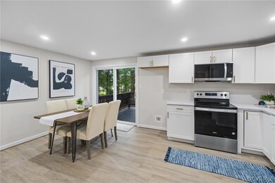 Kitchen with white cabinets, appliances with stain