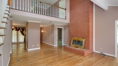 Spacious living room with wood burning fireplace and hardwood floors. 