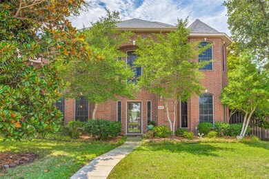 View of front facade featuring a front yard with mature trees
