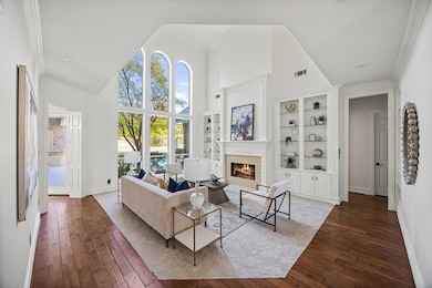 Featuring one of 5 fireplaces, the formal living room showcases stunning views of the pool beyond.