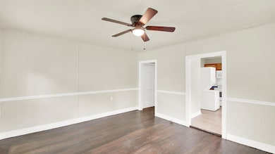 Spare room featuring dark wood finished floors and a ceiling fan