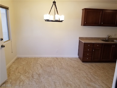 Unfurnished dining area featuring baseboards and a sink