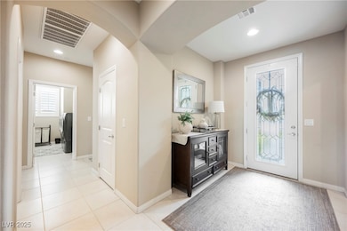 Foyer entrance featuring arched walkways, light tile patterned floors, washer / clothes dryer, and recessed lighting