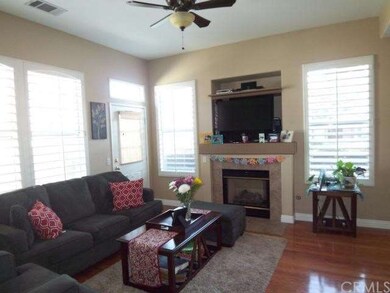 The living room features wood flooring, a cozy fir