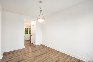 Unfurnished dining area featuring wood finished floors and a chandelier