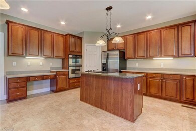 Spacious kitchen with lots of storage in the mahogany cabinets, stove top island and plenty of counter space.