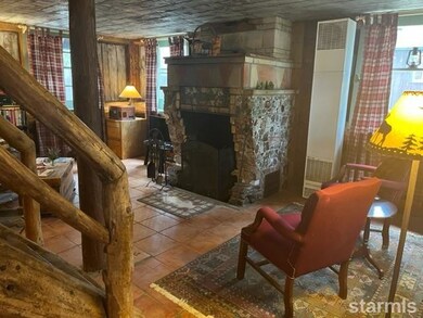 Living room in log cabin with unique rock fireplac