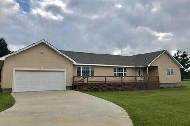 Ranch-style house featuring a front yard and a gar