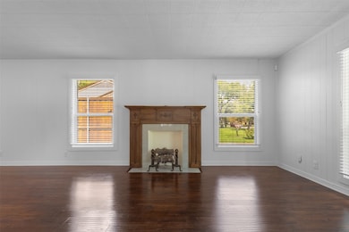 Unfurnished living room with dark wood-style floors, crown molding, and wood walls