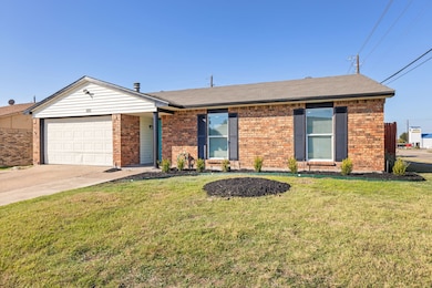 Ranch-style house featuring roof with shingles, a front yard, brick siding, and driveway